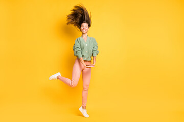 Fototapeta na wymiar Full size photo of young pretty beautiful happy joyful funky girl with flying hair isolated on yellow color background