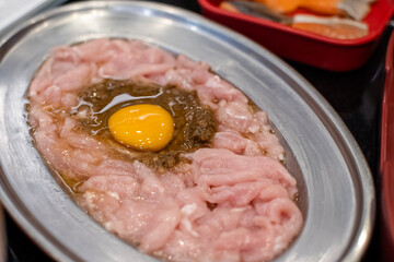 peper herb marinated sliced pork topped with egg yolk prepare for sukiyaki
