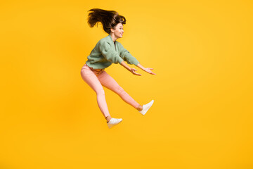 Fototapeta na wymiar Full size profile side photo of young happy positive crazy smiling girl look copyspace jumping isolated on yellow color background