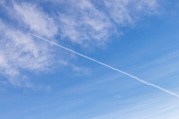 High white cirrus clouds with cirro-stratus in a light blue sky, sometimes called chair tails, indicate nice weather, but stormy changes come within a few days. Chemtrails on a blue sky