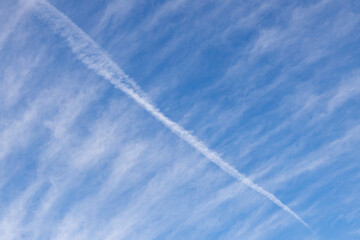 High white cirrus clouds with cirro-stratus in a light blue sky, sometimes called chair tails, indicate nice weather, but stormy changes come within a few days. Chemtrails on a blue sky