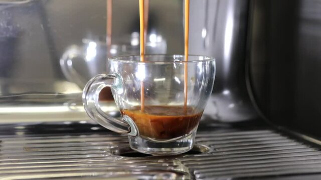 Frisch gemahlener Kaffe wird zu Espresso verarbeitet. Espressoshot am Morgen. Eine Espressotasse wird mit Kaffee gef&uuml;llt. 