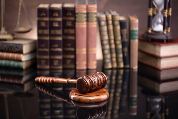 Law theme. Judge chamber. Judge&rsquo;s gavel, scale and collection of legal books on the brown desk and the brown background.
