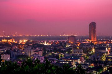 The high angle background of the city view with the secret light of the evening, blurring of night lights, showing the distribution of condominiums, dense homes in the capital community