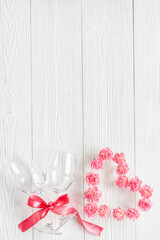 Valentines Day dating dinner with wine glasses and pink flowers. Wedding or birthday background