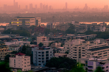 Naklejka premium The high angle background of the city view with the secret light of the evening, blurring of night lights, showing the distribution of condominiums, dense homes in the capital community