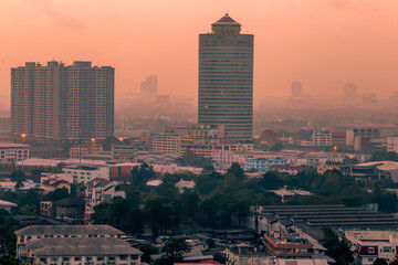 Fototapeta premium The high angle background of the city view with the secret light of the evening, blurring of night lights, showing the distribution of condominiums, dense homes in the capital community