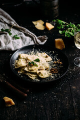 Ravioli with spinach, ricotta and parmesan on a black plate