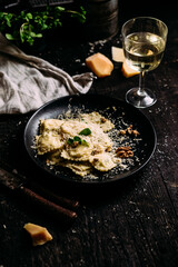 Ravioli with spinach, ricotta and parmesan on a black plate