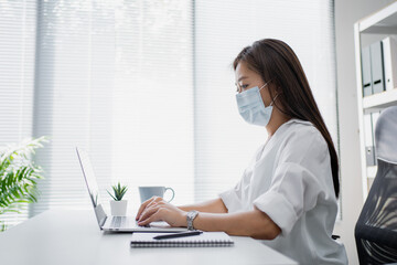 Business women feel sick. She wear masks to protect and take care of their health in the office.