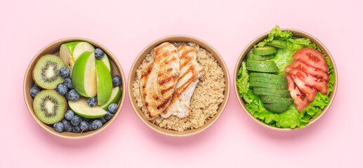Healthy eating concept. Vegetable avocado salad, quinoa with chicken breast, fruits and berries. Varied meals for every day in eco paper containers