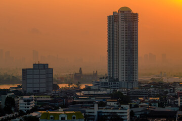 Fototapeta premium The high angle background of the city view with the secret light of the evening, blurring of night lights, showing the distribution of condominiums, dense homes in the capital community