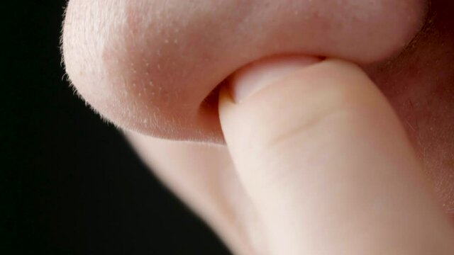 Close-up video of woman picking her nose
