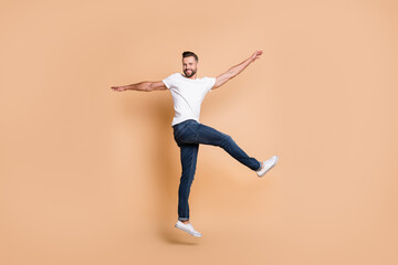Full length body size view of attractive funky cheerful guy jumping having fun dancing isolated...