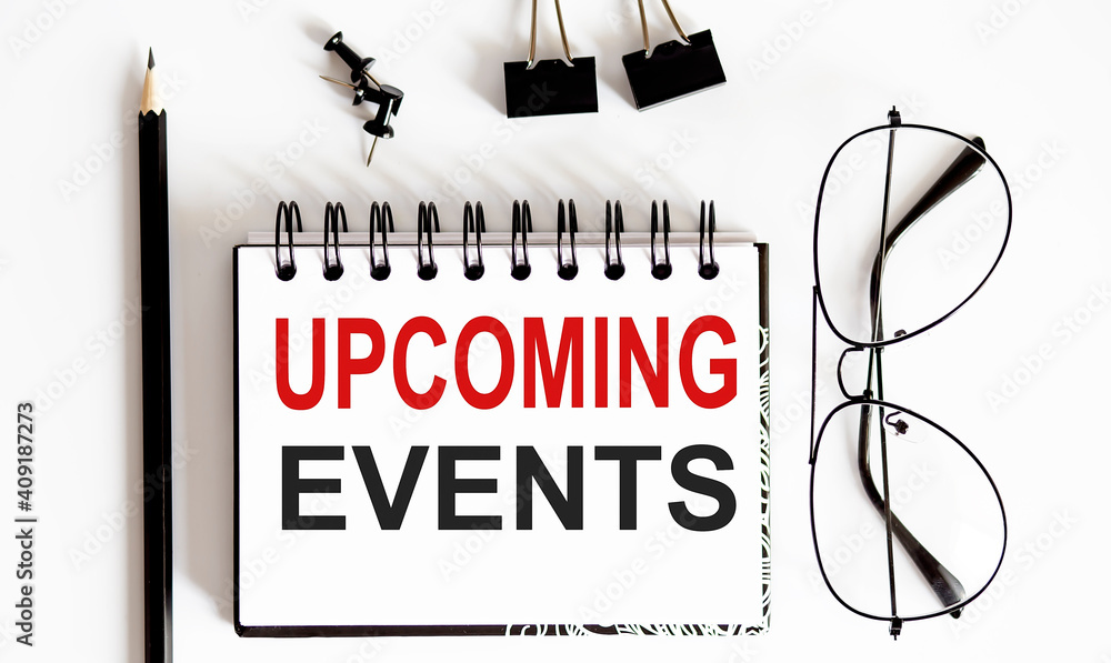 Poster upcoming events text written on a notebook with pen and glasses