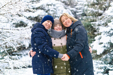 Fototapeta na wymiar family portrait in the winter forest, one parent and two children, beautiful nature with bright snowy fir trees