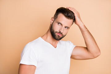 Photo of young handsome man enjoy hair care treatment lotion hairdo look empty space isolated over beige color background