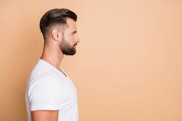 Profile side photo of young handsome confident man look empty space isolated over beige color background