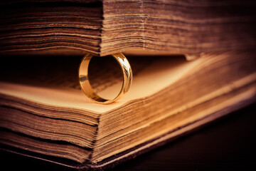 Golden ring between the pages of old book in vintage style