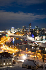 Vilnius, capital of Lithuania, beautiful scenic aerial panorama of modern business financial district architecture buildings with river and bridge in winter, vertical