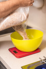 man weighs malt for brewing beer on scale