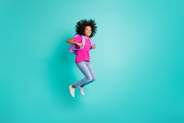 Photo portrait full body view of black skin schoolgirl jumping up isolated on vivid cyan colored background