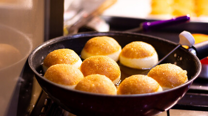 Fried dougnut with beautiful dark brown color in the pan, ready to serve