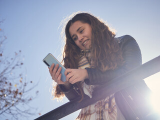 Shallow focus shot of a happy young female using her smartphone