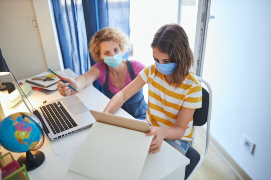 Child home studying education, homeschooling, with private tutor / mother with protective mask in the time of viruses, flu and seasonal pandemic.