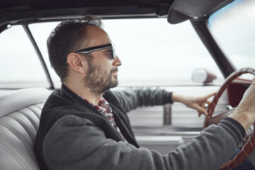 Man in retro clothes driving vintage American car.