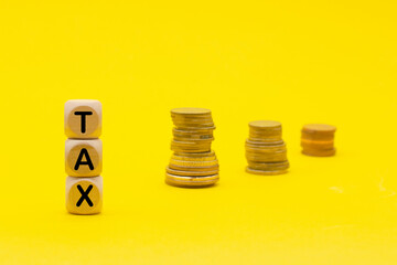 Wooden cubes with the word Tax on money climbing staits, pile of coins on yellow background ,Tax Concept