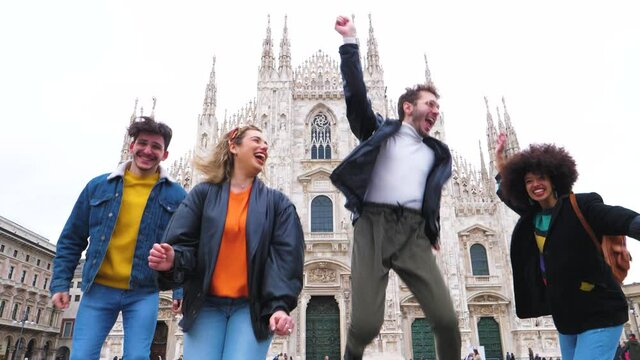 Group of for multiethnic people friends jumping in front of milan cathedral - celebration, freedom, victory concept