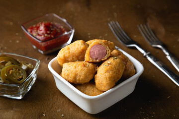 Mini corn dog with ketchup and jalapeno pepper