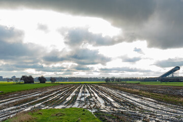 Threatening clouds over a wet Meerpolder. On the right, the covered ski slope of Snowworld heads far above the landscape