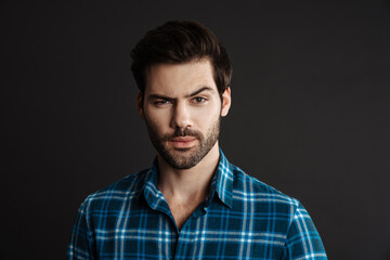 Thinking handsome unshaven guy posing and looking at camera