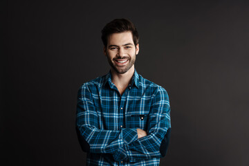Joyful handsome brunette guy smiling and looking at camera
