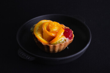 Cheese dessert with orange on a black background