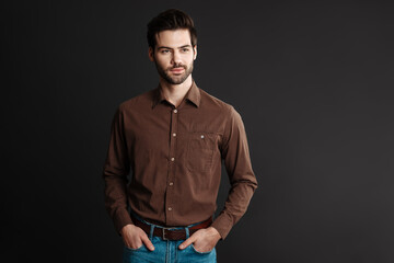 Obraz premium Pleased handsome unshaven guy posing and looking aside