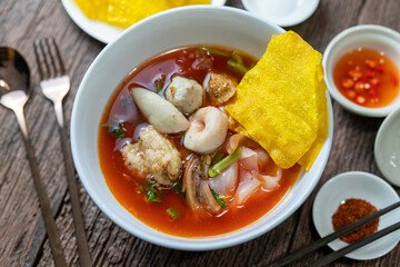 Asian Pink Noodle Soup or Yen Ta Fo noodle with fish ball, crispy wonton in special homemade red sauce.