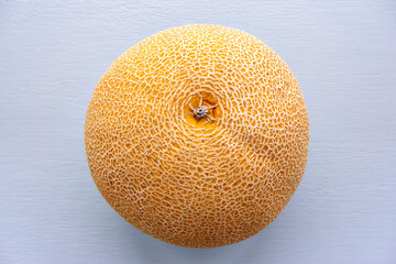 Top view image of honeydew melon with skin texture on a light background. Honeydew melon is the fruit of one cultivar group of the muskmelon, Cucumis melo in the gourd family.