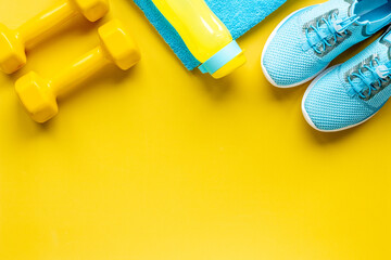 Flat lay of fitness gym equipment with sneakers and bottle of water