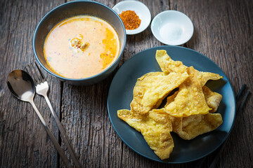 Crispy Wonton Noodles in hot and spicy Soup with fish balls, Crispy pork, and special homemade Soup. Tom Yum Thai noodles soup.