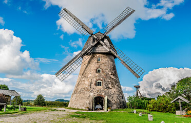 Fototapeta na wymiar Rural or rustic landscape with old windmill and clouds