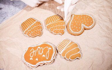 Anonymous woman decorating some homemade gingerbread cookies at kitchen