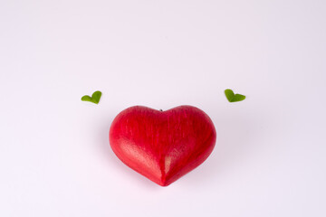 Red love heart  and two clover leaves flying above, giving a feeling of joy and lightness, as the heart seems to fly. Concept of love, Valentine