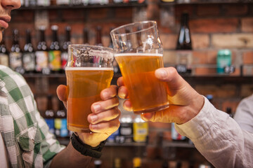 Unrecognizablemen clinking beer glasses