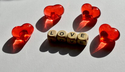 The letters on the four wooden cubes make up the word love and four red hearts