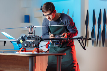 Image of Male Engineer or Technician with Remote Control in His Hands Programs Drone.