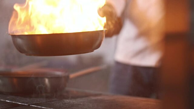 chef shows his professionalism by making an enchanting fire show while cooking meat