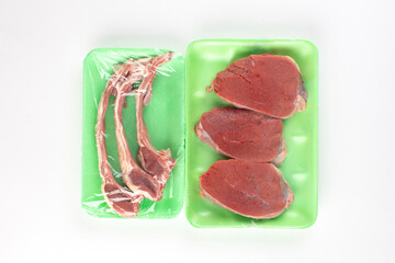 Beefsteak and lamb ribs in green plastic container